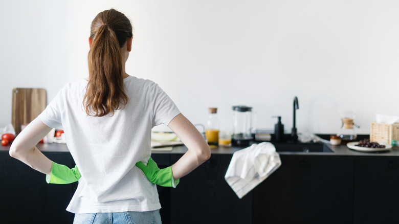 A person looking at countertop clutter in kitchen