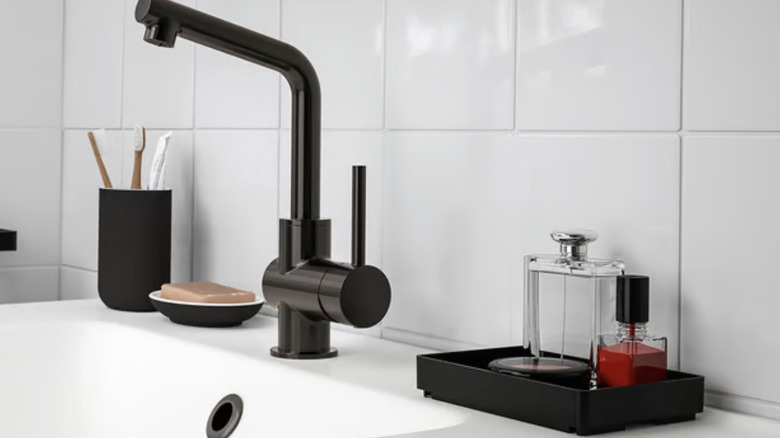 Small tray with perfume next to a bathroom sink