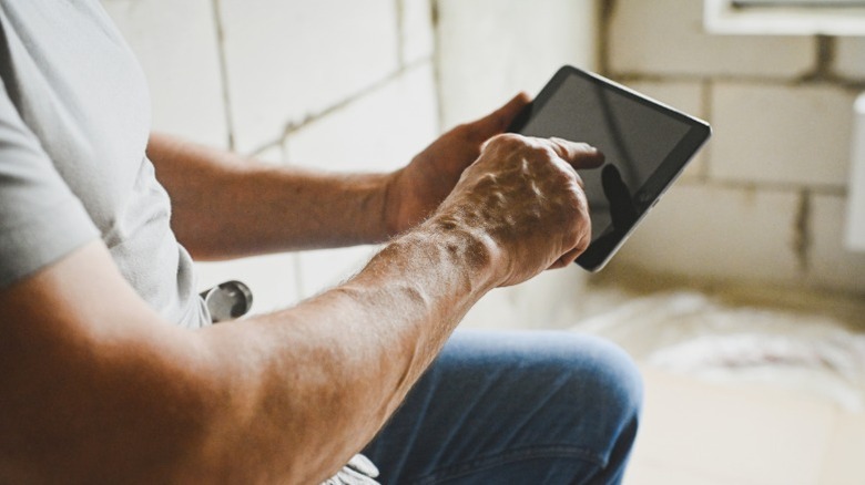 DIYer consulting an app on a tablet during a construction project