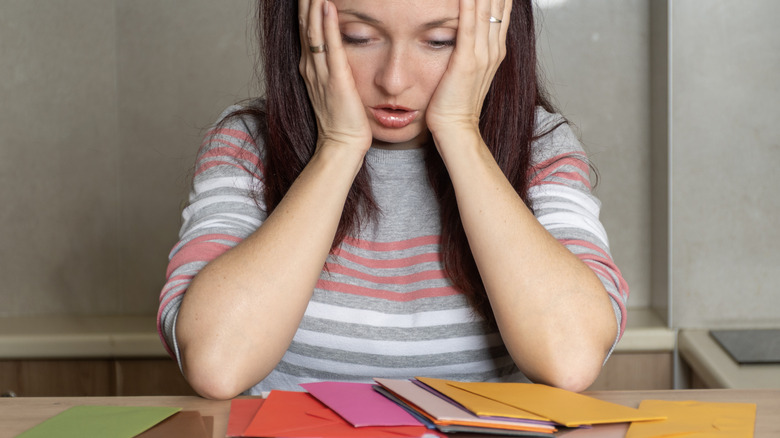 Woman looking at piles of mail on counter