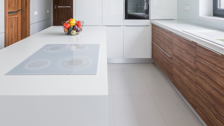 a very sleek, modern, minimalist kitchen in all white with some wood cabinets