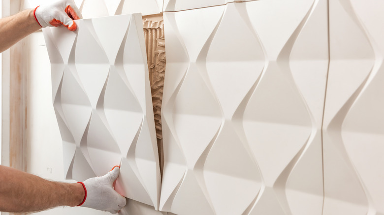 Worker installing a 3D wall panel