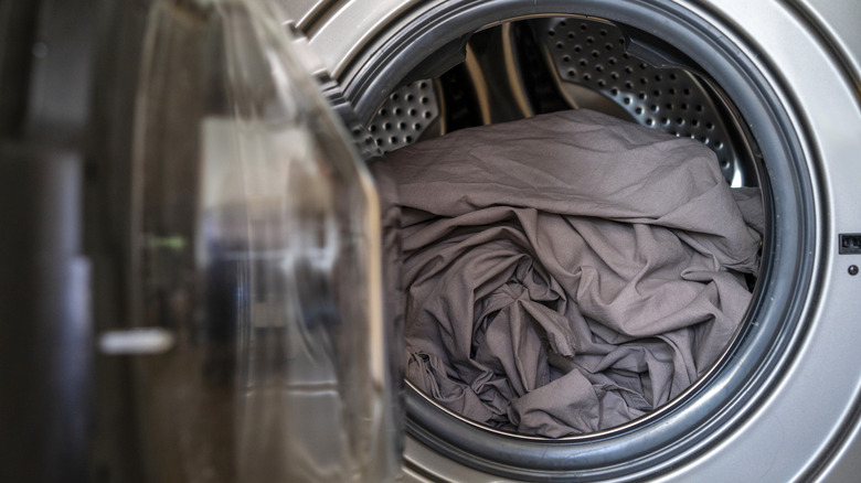 gray sheets loaded inside a washing machine