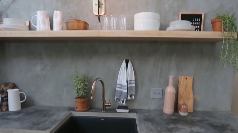 A kitchen with a concrete countertop and backsplash
