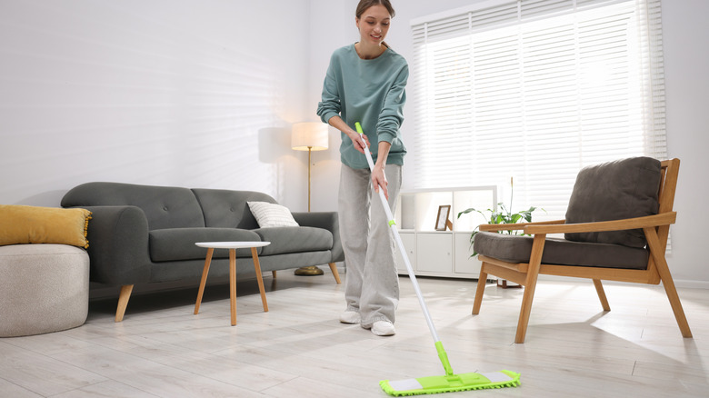 Woman cleaning floors with mop with reusable microfiber cloth