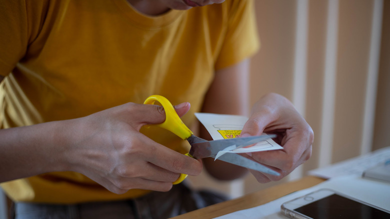 A person using scissors to cut into paper
