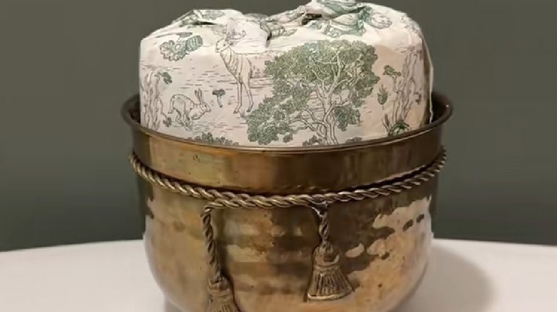 Toilet paper wrapped in napkin sitting inside vintage bowl