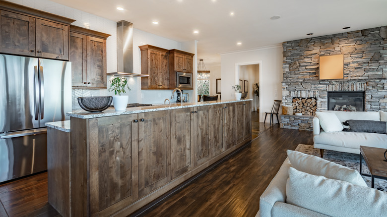Extra long kitchen island in natural wood, separating living area from cooking area