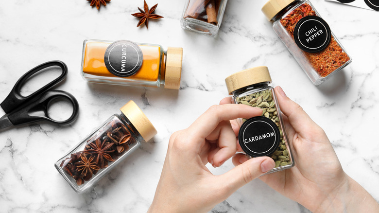 A person labeling spice jars with stickers