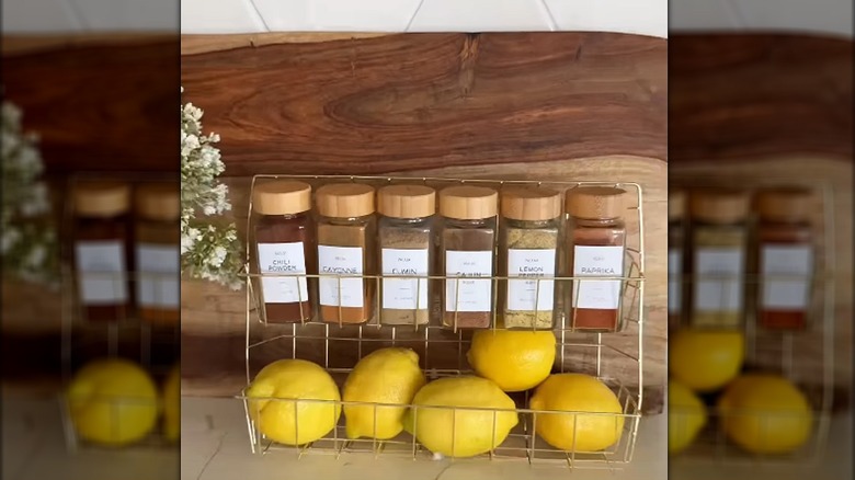 DIY spice rack made from Dollar Tree wire bins holding jars of spices and lemons