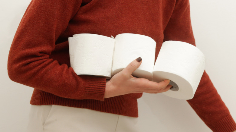 A woman organizes toilet paper