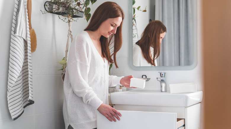A woman organizing her small bathroom