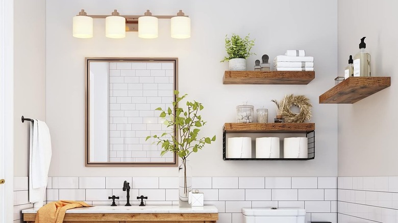 three sleek wooden shelves hang on the wall of a modern bathroom