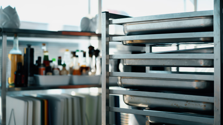 Close-up of speed rack with pans in organized kitchen