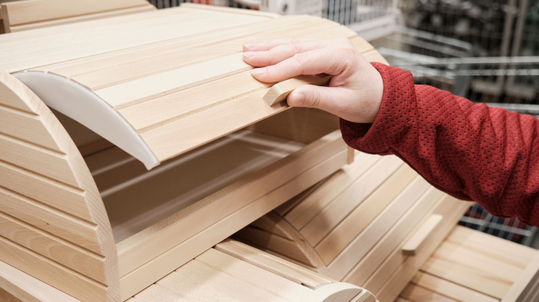 Person opening up wooden bread box
