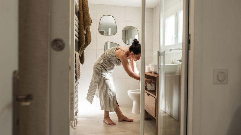A woman organizing her bathroom vanity