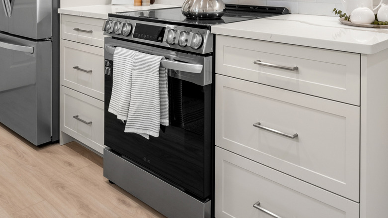 Two striped towels hanging on the handle of a stove