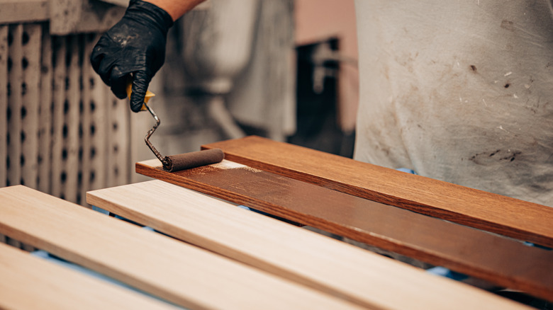 Woodworker applying wood stain to a project