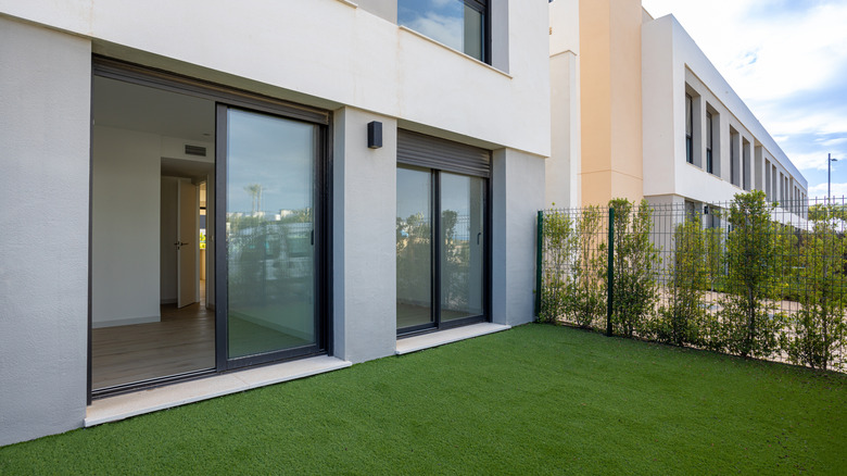 Sliding glass doors leading to a small lawn