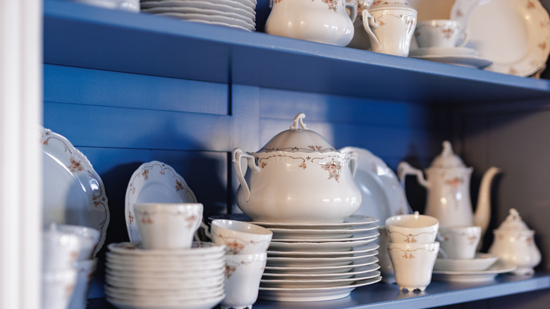 White china set of dishes on blue shelf
