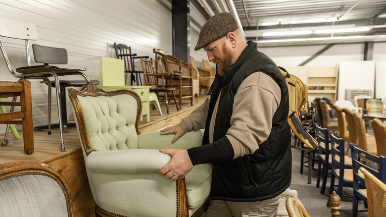 Man inspecting a chair at a thrift store