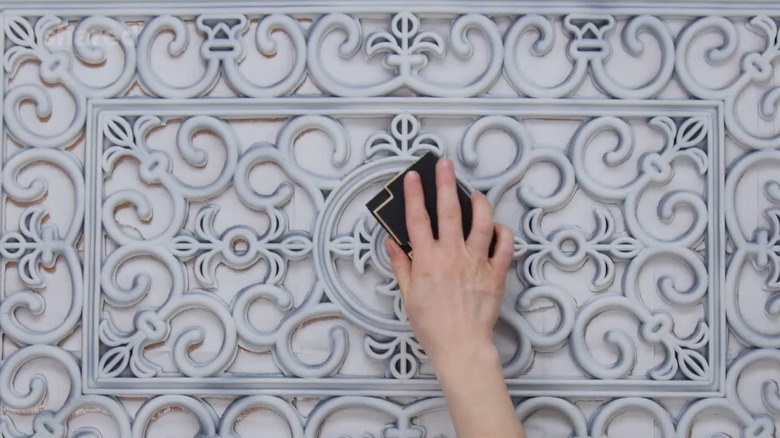 Person sanding a rubber door mat as part of a DIY project
