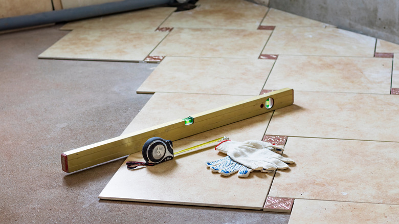 ceramic tile partially laid down on a floor