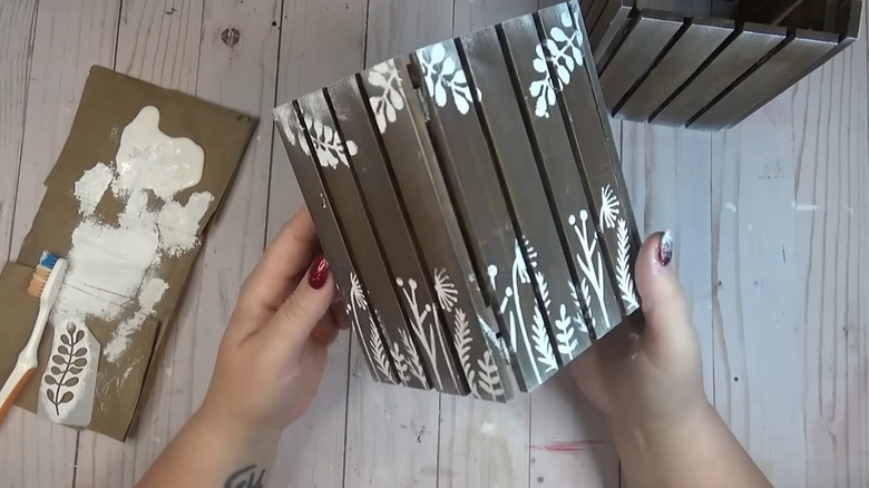 Creator holding up her solar patio light cover made from Dollar Tree pallets