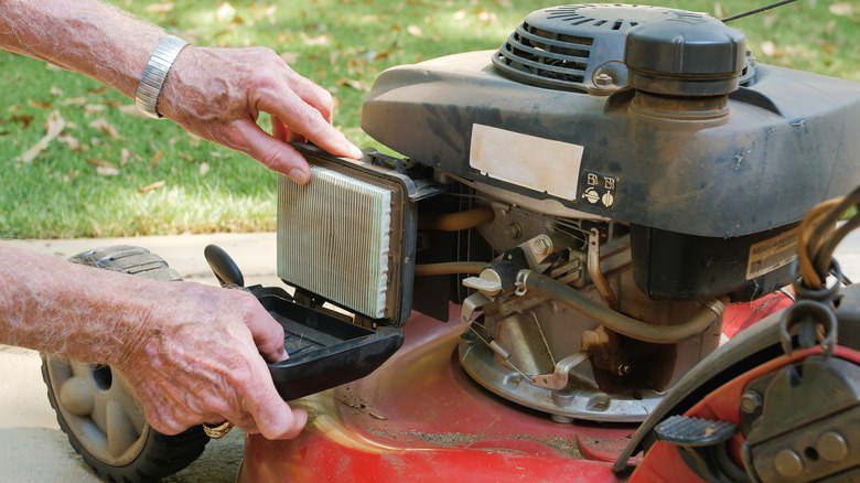 Man replacing the air filter on a lawn mower.