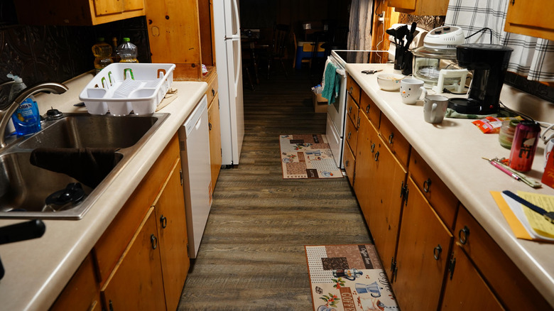 Cluttered kitchen with oak cabinets