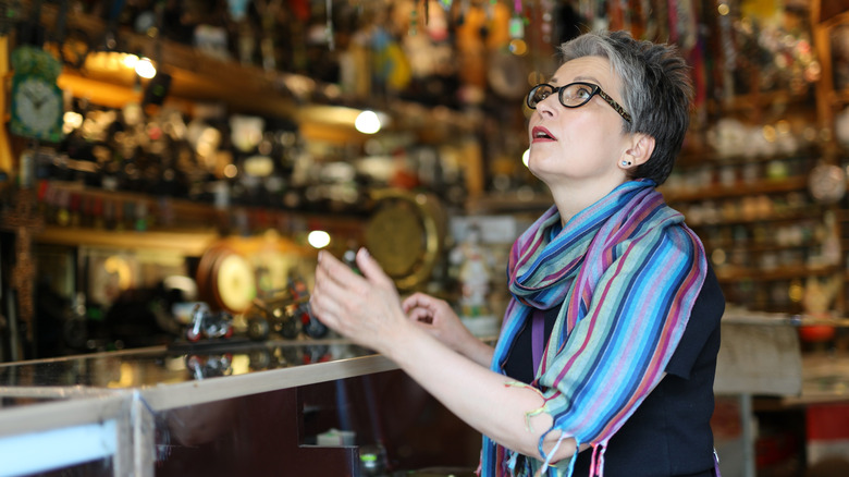 An older woman spots something at a colorful antique store