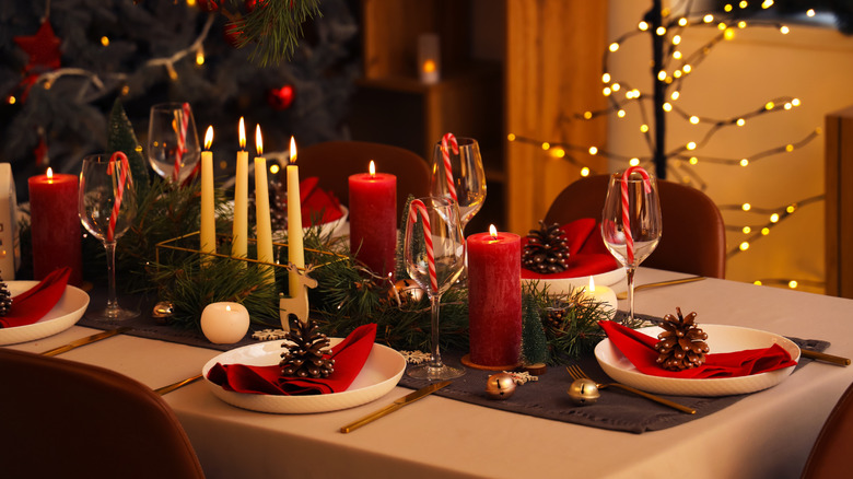 Festive Christmas table  with candles, pine cones, and candy canes