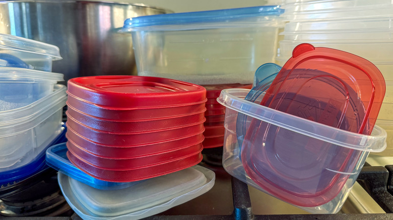 Stacks of plastic containers and lids in kitchen