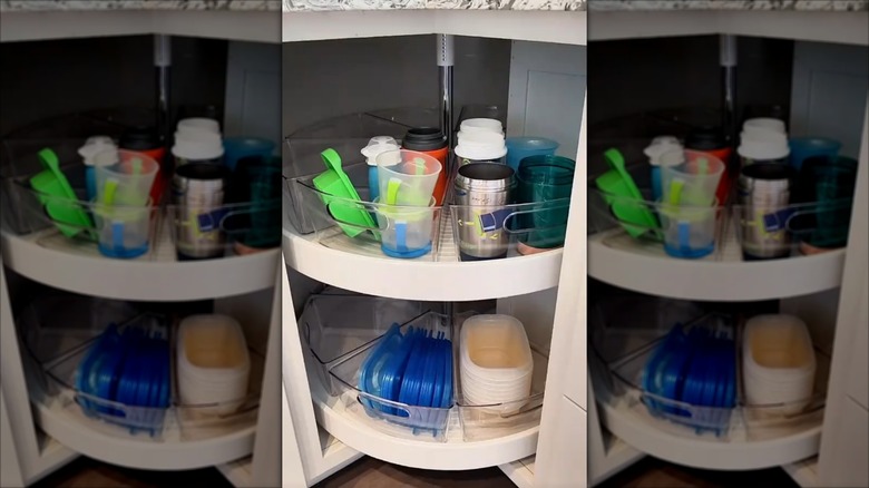 Wedge-shaped plastic tubs with plastic lids in them on a lazy Susan in a corner cabinet