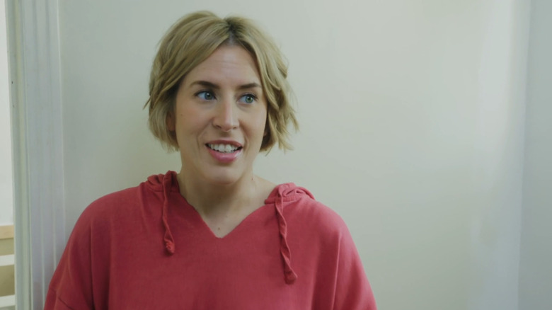 A headshot of Erin Napier, a woman with cropped blonde hair in a red sweater