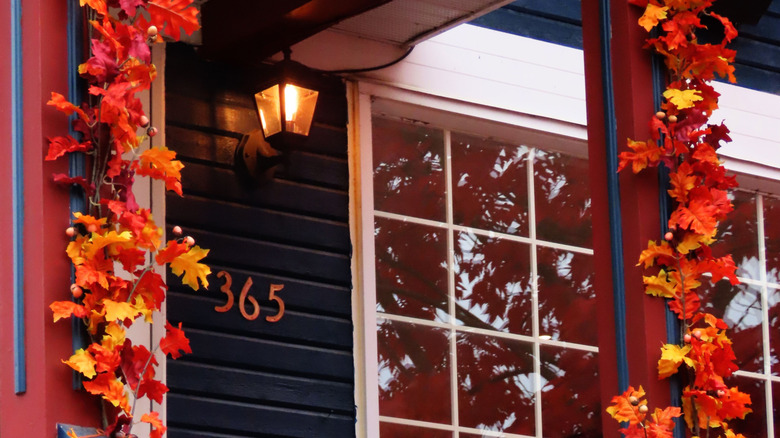 A front porch with faux leave garland