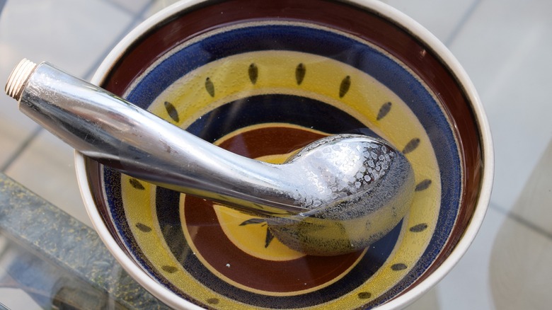 A shower head immersed in a citric acid cleaning solution will remove mineral deposits.