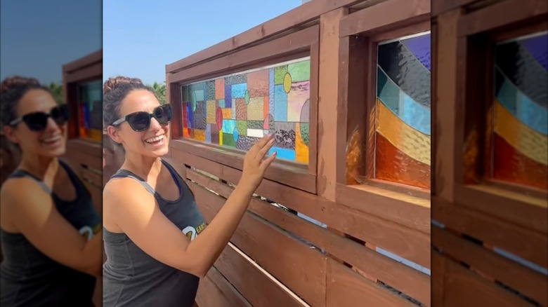 woman checking out her new custom wooden fence with upper stained glass privacy panels
