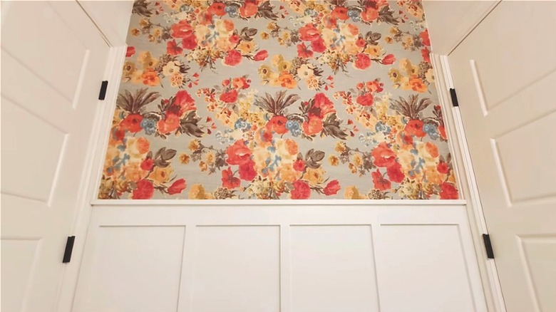 Floral-print fabric as accent wall in hallway between two doors