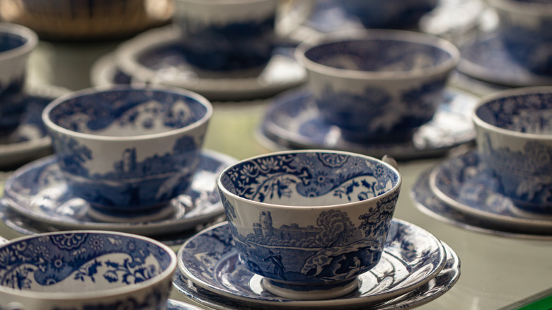 Ceramic blue and white Spode tea cups on white table background.