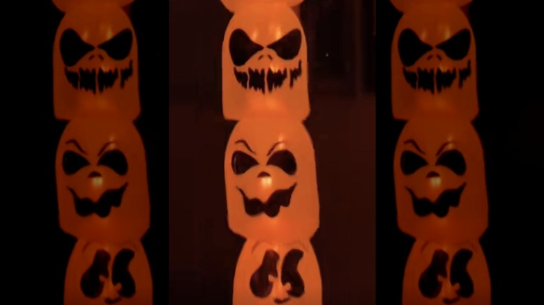 A DIY jack-o'-lantern basket garland with orange lights outside at night