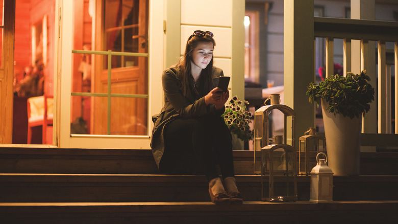 A person sitting on the front porch in the evening