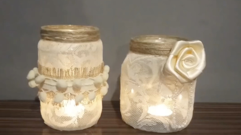 DIY lanterns with tulle, jute, and floral accents made from glass jars