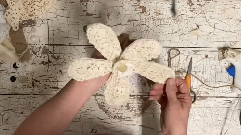Hands holding flower decor made using metal whisk