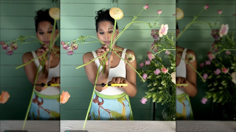 Woman using whisk to separate flowers in DIY bouquet