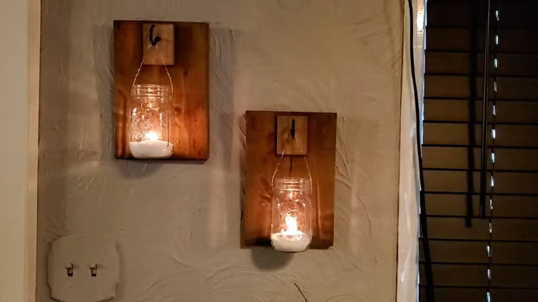 Two Mason jar sconces hanging on a wall
