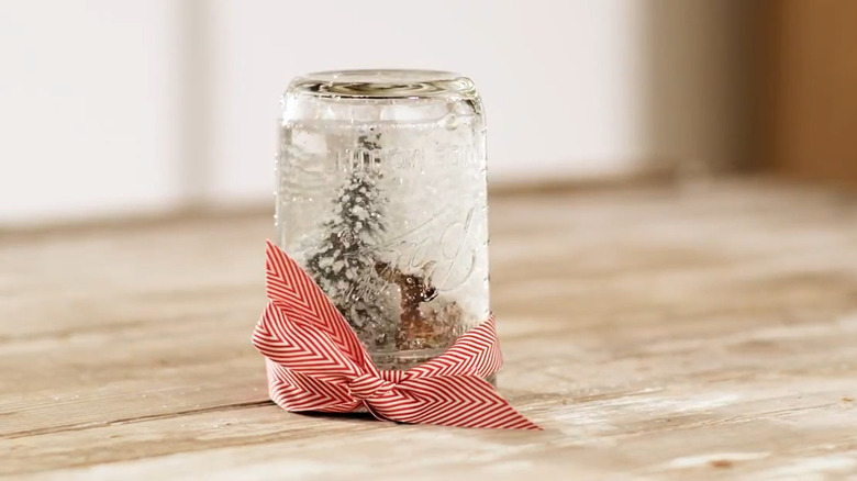 Snow globe with a deer and tree inside a Mason jar