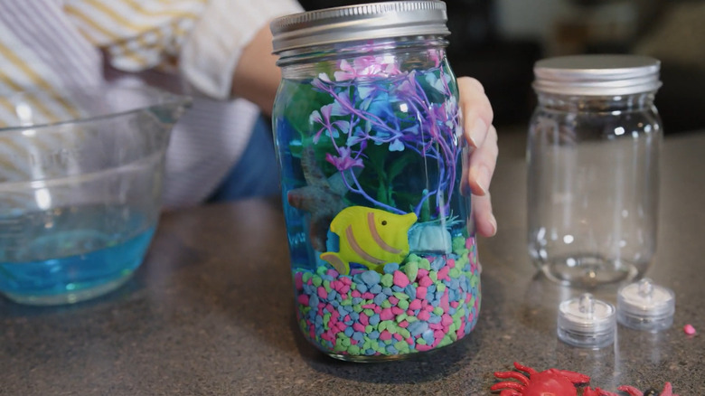Creator holding a mini aquarium made with a Mason jar