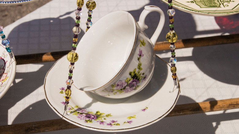 Teacup and saucer hung with beads to feed birds