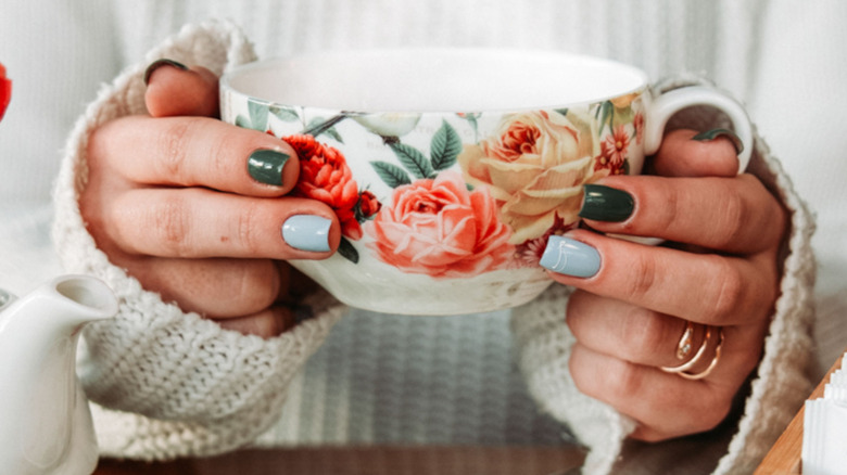 Woman holding up an old-fashioned teacup